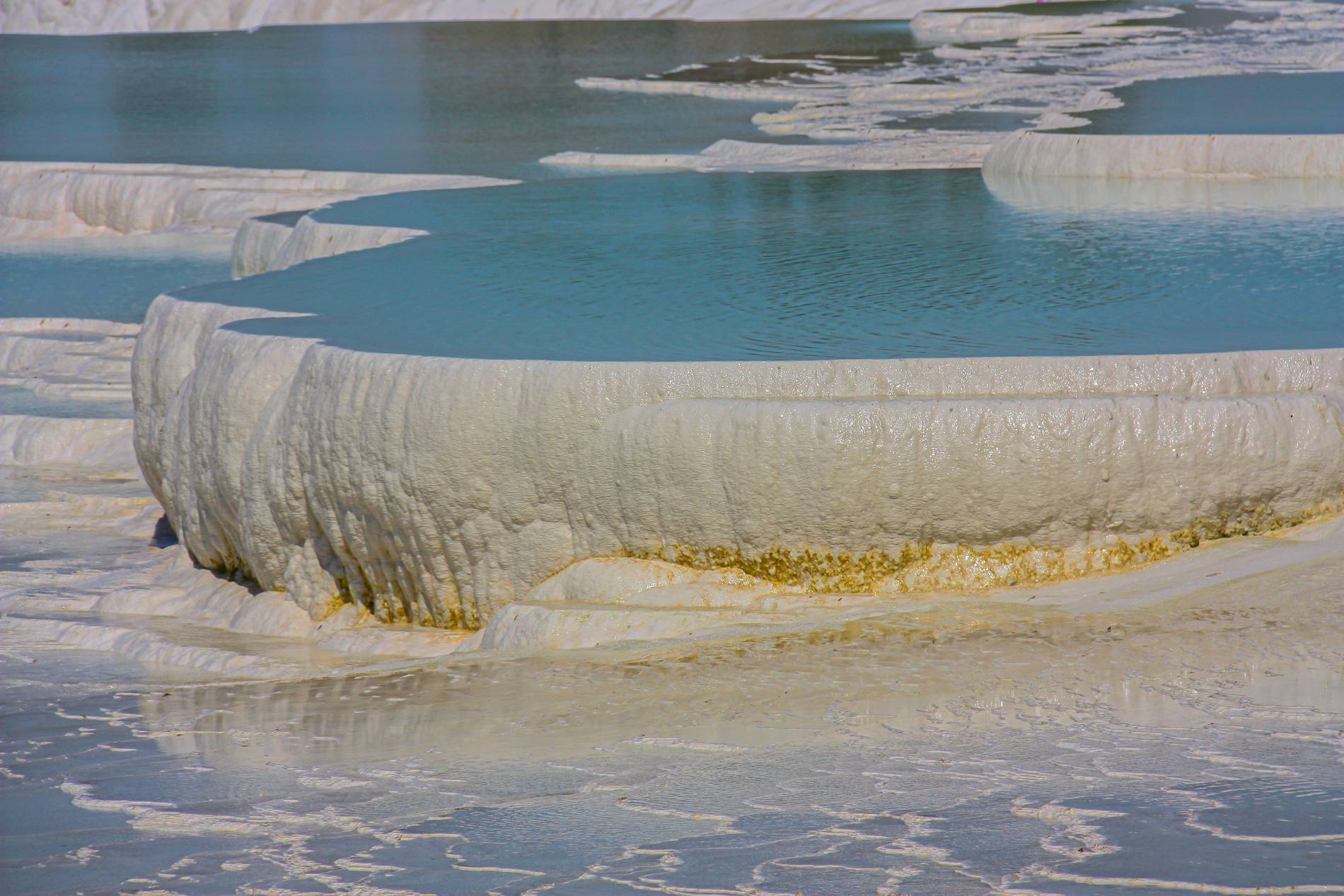 Turquoise water pooling in white travertine basins on the slope at Pamukkale